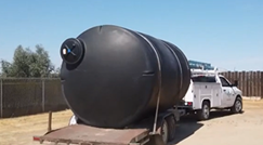 Large water tank on a trailer pulled by a pick-up truck
