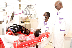 Two dentists attending a young patient in a dental chair