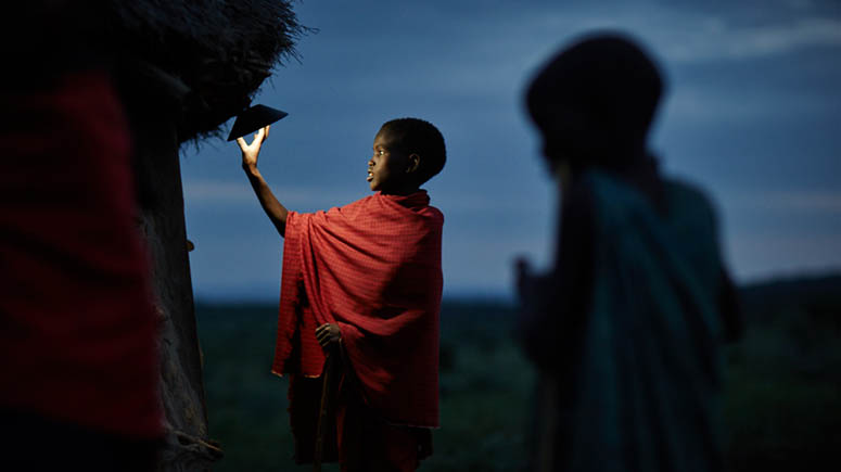 Child in rural African village turning on a light